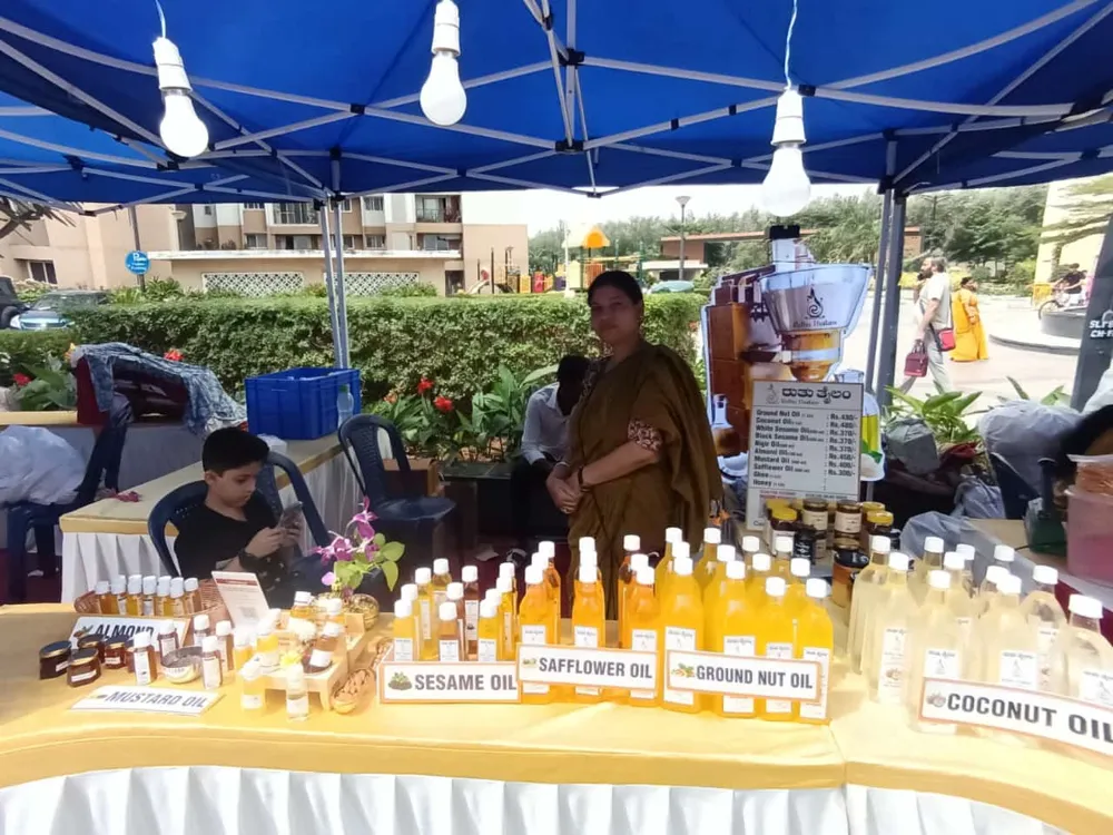 Ruthu Thailam stall with oil bottles under a tent at a local event