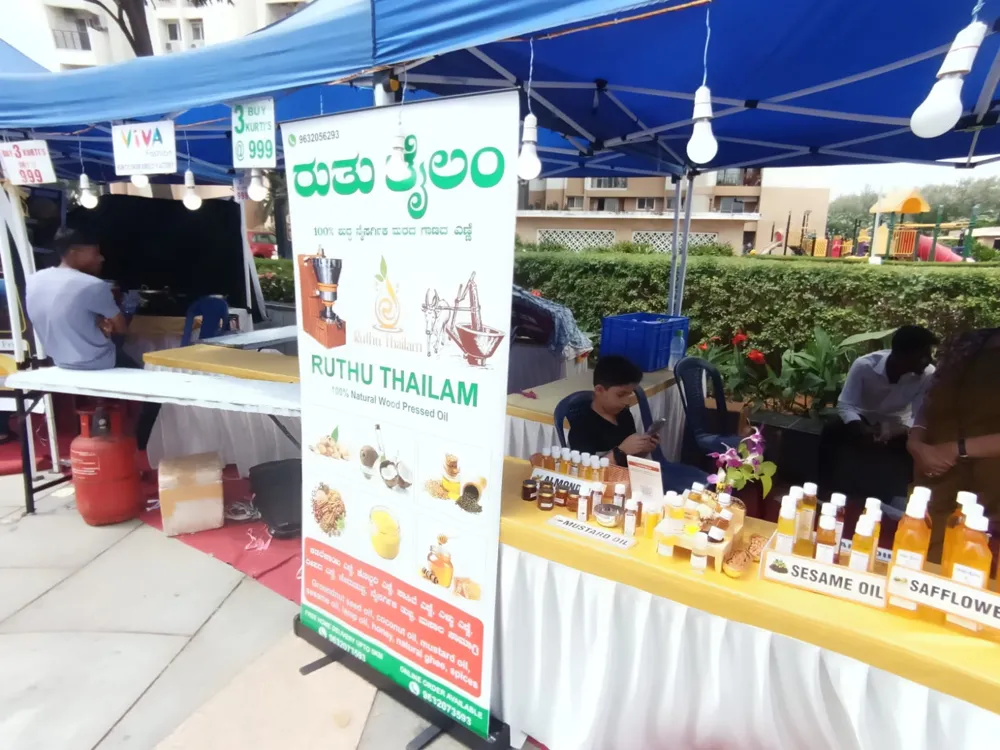 Ruthu Thailam stall banner and oils on display at an event